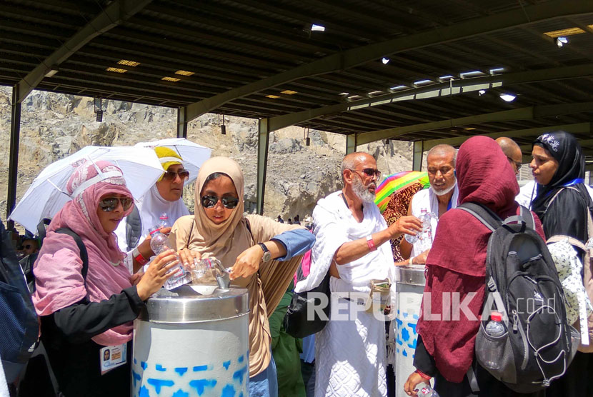 Jamaah haji minum air putih karena keletihan saat berjalan kaki menuju Makkah, usai melontar jumrah di Mina, Senin (12/9). (Republika/ Amin Madani)