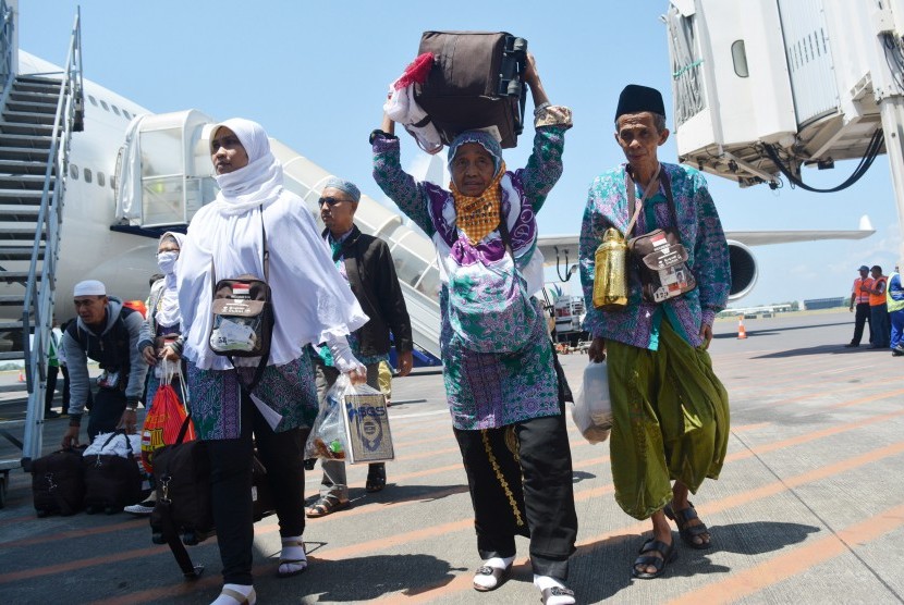 Jamaah haji yang tergabung dalam kelompok terbang (kloter) pertama tiba di Bandara Internasional Juanda Surabaya di Sidoarjo, Jawa Timur, Minggu (18/9). 