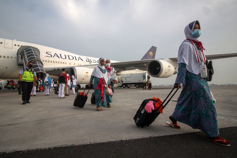 Jamaah haji yang tergabung dalam kelompok terbang (kloter) pertama tiba Terminal 2 Bandara Internasional Juanda Surabaya di Sidoarjo, Jawa Timur, Ahad (17/7/2022).  Sebanyak 18 orang jamaah haji Indonesia positif Covid-19 sepulang dari Arab Saudi. Ilustrasi.