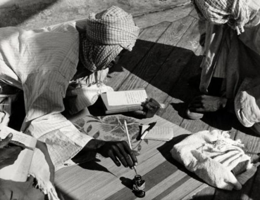 Jamaah haji zaman dahuku tengah menulis catatan di atas kapal yang hendak ke Mekkah.