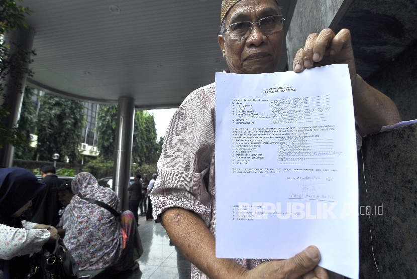 Jamaah korban dugaan penipuan perjalan umrah First Travel memperlihatkan formulir pengaduan di Kantor Bareskrim Polri Gambir, Jakarta Pusat, Selasa (22/8).
