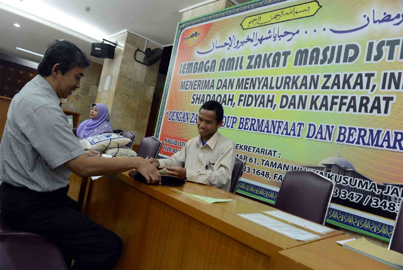   Jamaah membayar zakat fitrah di Masjid Istiqlal, Jakarta Pusat, Selasa (5/8).  (Republika/Agung Supriyanto)