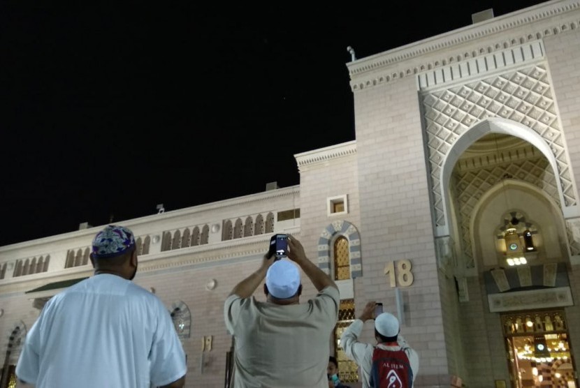 Jamaah mengambil gambar gerhana bulan di Masjid Nabawi, Madinah, Jumat (27/7) malam waktu setempat. Kesempatan langka itu digunakan jamaah haji tahun ini mengikuti shalat sunah Khusuf di masjid bersejarah tersebut.