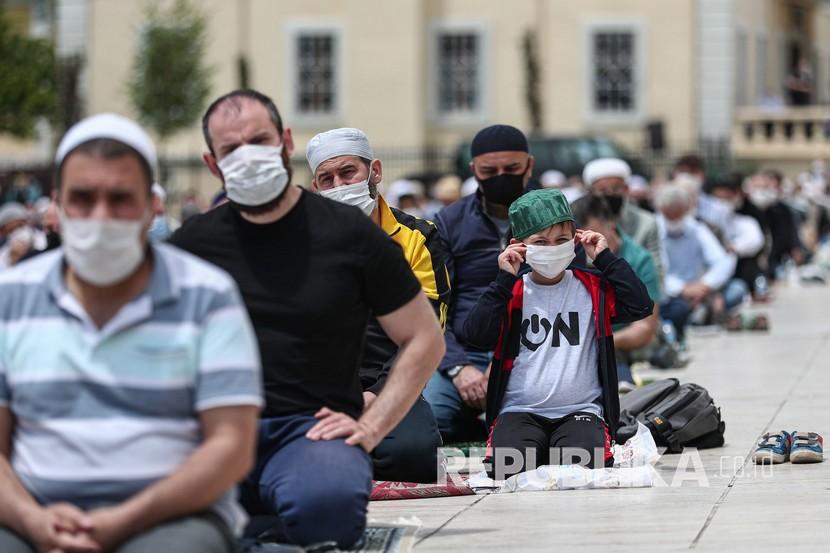 Jamaah menggunakan masker saat mereka sholat Jumat di Masjid Fatih, Istanbul, Turki, Jumat (29/5). Shalat Jumat setelah 74 hari dengan jarak sosial di tengah pandemi virus corona.  