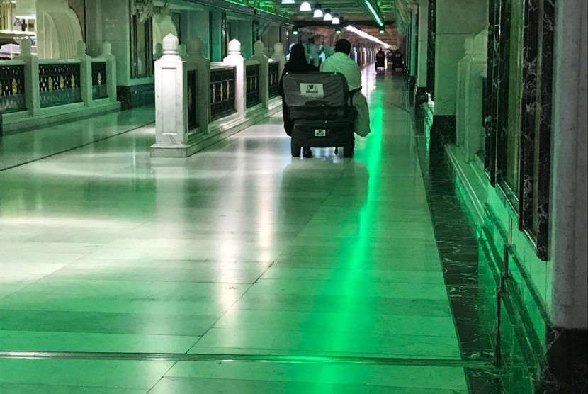 Jamaah tengah mengendari kursi dorong di lorong Masjidil Haram, Makkah.