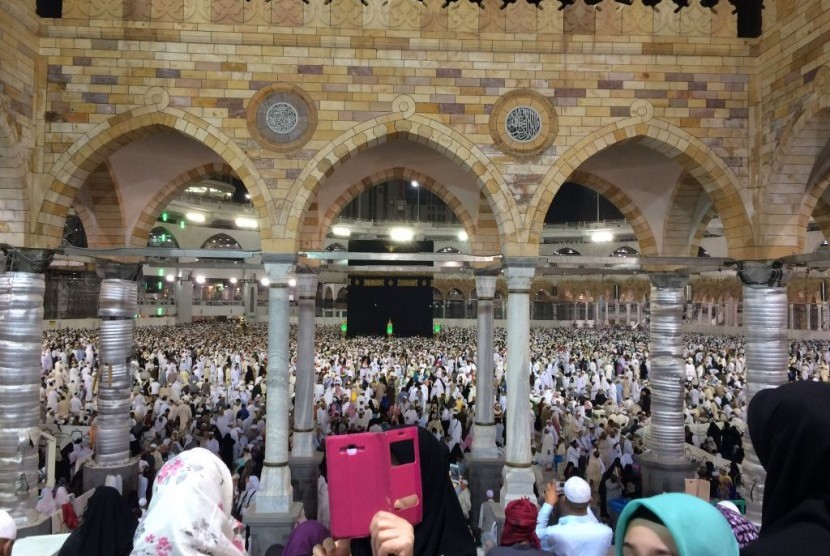Jamaah umrah berswafoto dengan latar Kabah di Masjidil Haram.