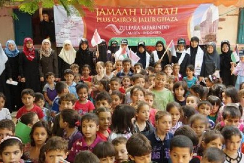 Jamaah umroh Indonesia berdiri di belakang bersama anak-anak Palestina di Gaza.