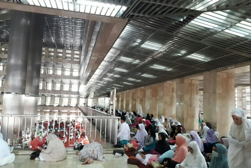 Jamaah wanita peserta Aksi 313 bersiap mengikuti Shalat Jumat di selasar selatan Masjid Istiqlal, Jumat (31/3).  