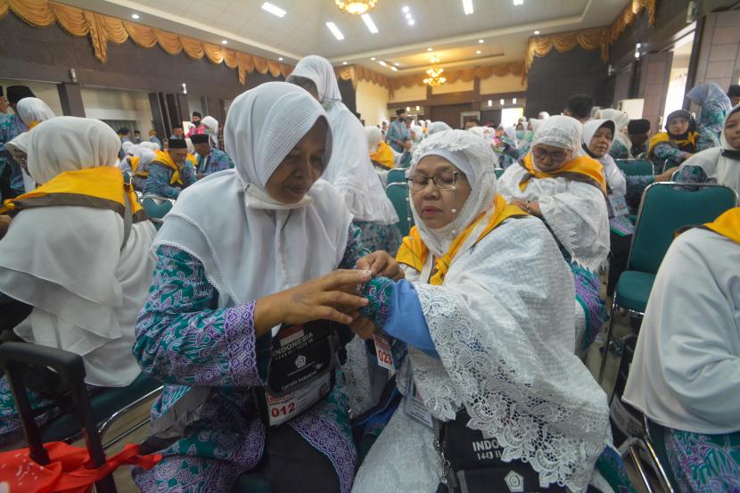 Jamah calon haji kelompok terbang (kloter) 1 embarkasi haji Padang memasang gelang haji setibanya di Asrama Haji Tabing, Kota Padang, Sumatra Barat, Jumat (3/6/2022).