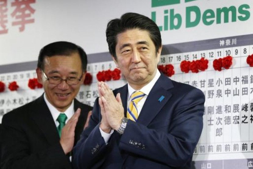 Japan's Prime Minister Shinzo Abe, who is also leader of the ruling Liberal Democratic Party (LDP), claps during an election night event at the LDP headquarters in Tokyo, December 14, 2014.