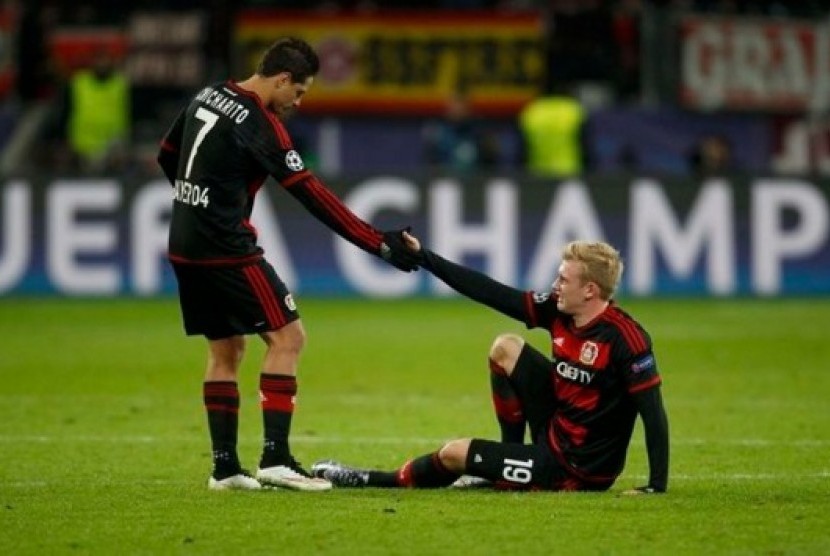 Javier Hernandez (kiri) menarik tangan rekannya Julian Brandt.