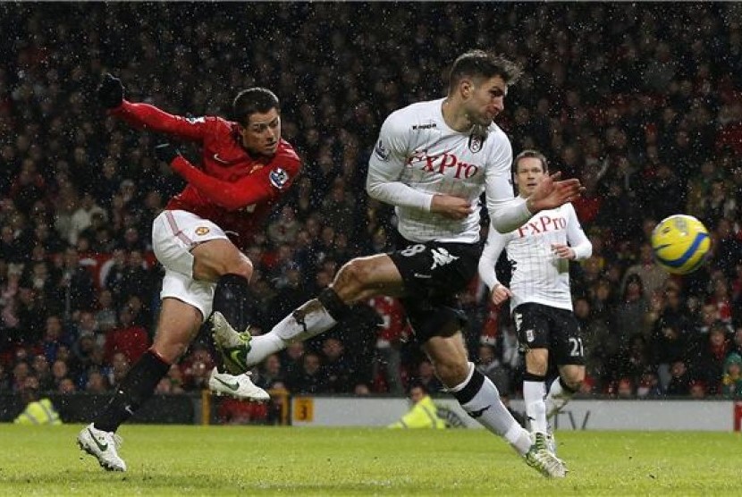 Javier Hernandez (kiri), striker Manchester United, melepaskan tembakan menjebol jala Fulham di putaran keempat Piala FA di Stadion Old Trafford, Manchester, Selasa (26/1). 