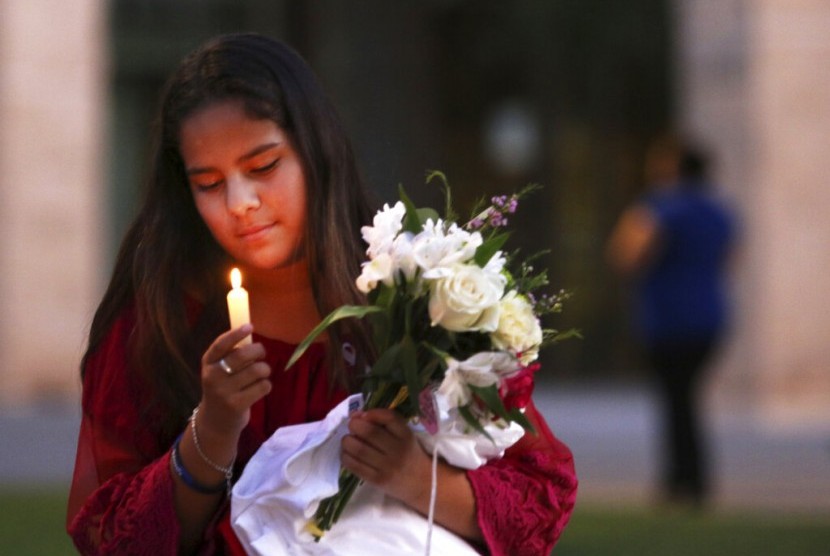 Jaxciri Solano menyalakan lilin saat peringatan mengenak korban penembakan di Odessa, Texas, Ahad (1/9).