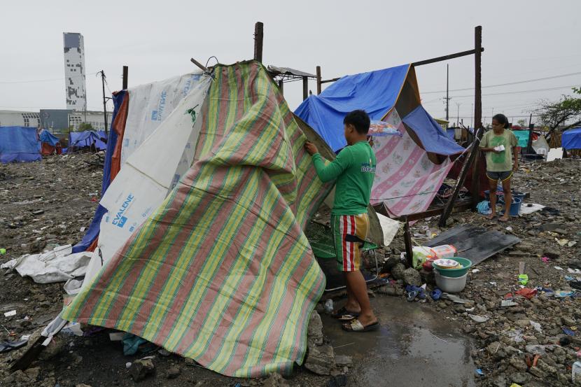 Jay Rabina memperbaiki tenda setelah rumahnya rusak akibat Topan Rai di Mambaling, Cebu, Filipina. Federasi Internasional Masyarakat Palang Merah dan Bulan Sabit Merah (IFRC) memperkirakan Topan Rai telah merusak 1,5 juta rumah di Filipina. 
