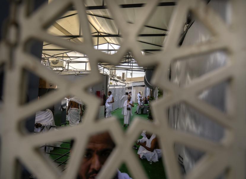Jamaah haji terlihat melalui pagar di tenda perkemahan Mina selama haji, di Mekah, Arab Saudi, Kamis, 7 Juli 2022. 