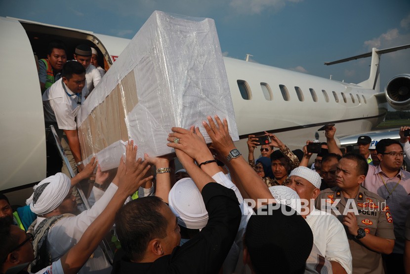 Jemaah membawa peti berisi jenazah Ustad Arifin Ilham yang baru tiba dari Penang, Malaysia di Bandara Halim Perdanakusuma, Jakarta Timur, Kamis (23/5/2019). 
