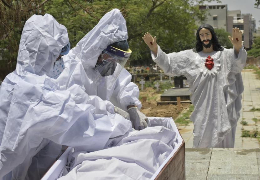 Jenazah korban COVID-19 dipersiapkan untuk dimakamkan di pemakaman Kristen di New Delhi, India, Sabtu, 29 Mei 2021. 