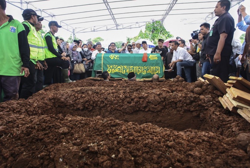 Jenazah korban pembunuhan Pulomas Dodi Triono siap dimasukan ke liang lahat pada proses pemakaman di TPU Tanah Kusir, Jakarta, Rabu (28/12). 