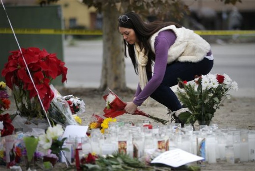 Jennifer Caballero meletakkan karangan bunga untuk mengenang korban penembakan San Bernardino, Jumat (4/12).