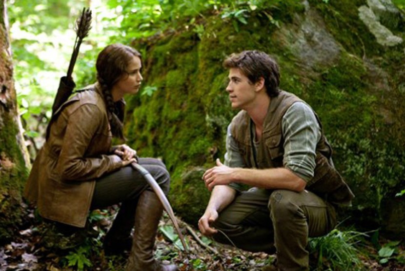 Jennifer Lawrence, kiri, memerankan Katniss Everdeen dan Liam Hemsworth sebagai Gale Hawthorne dalam sebuah adegan di 