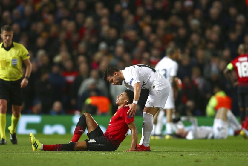 Jesse Lingard terduduk di lapangan menahan sakit.