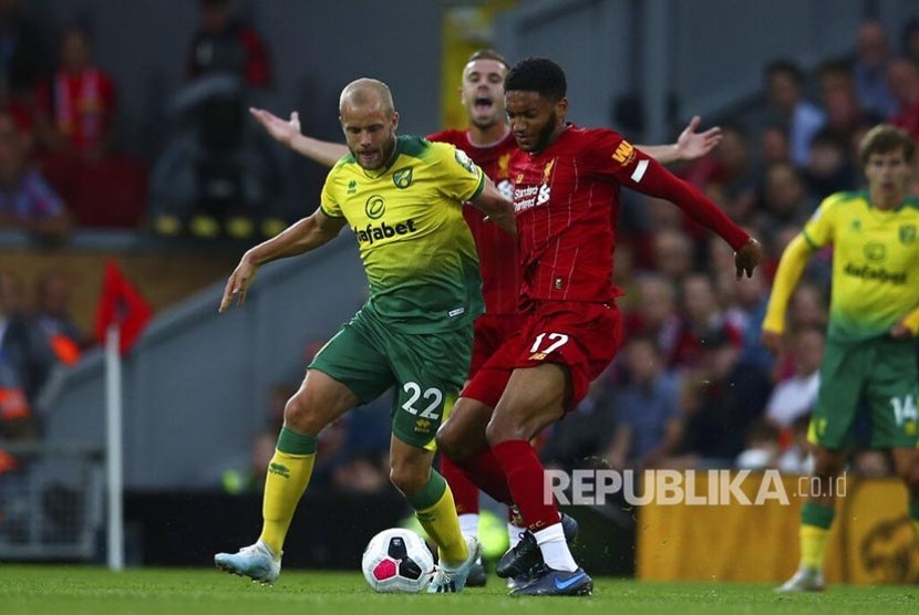 Joe Gomez (kanan) dan Teemu Pukki (kiri) berebut bola pada laga liga Inggris antara Liverpool  melawan Norwich City  di Anfield Stadium, Liverpool, Ahad (11/8) waktu setempat.