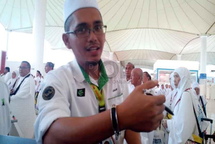 Johari, petugas haji dari Tabung Haji Malaysia, menunjukkan gelang haji digital saat mendampingi jamaah haji asal Malaysia, di Bandara Internasional King Abdul Aziz Jeddah. Tahun 2022, Tabung Haji membagikan keuntungan 3,1 persen pada jamaah, sama secara porsi dengan 2021 namun beda secara nominal.