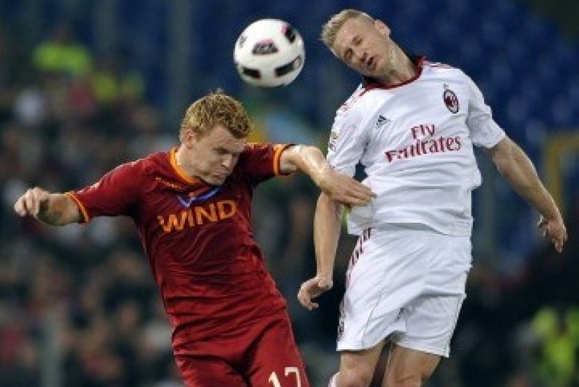 John Arne Riise (kiri), pemain AS Roma, terlibat duel udara dengan Ignazio Abate.