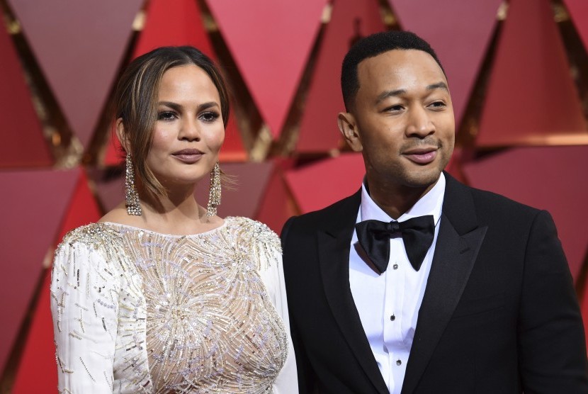 John Legend (kanan) dan istrinya Chrissy Teigen di karpet merah Piala Oscar, (27/2).