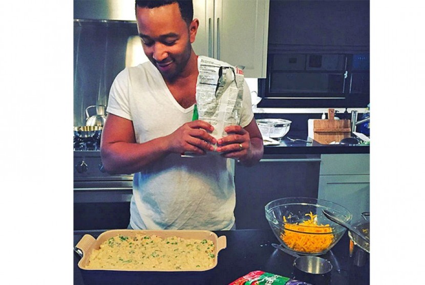 John Legend menyiapkan makanan di dapur. 