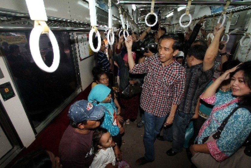 Joko Widodo berbincang dengan penumpang saat naik KRL menuju Depok di stasiun Tanah Abang, Jakarta, Senin (2/4).