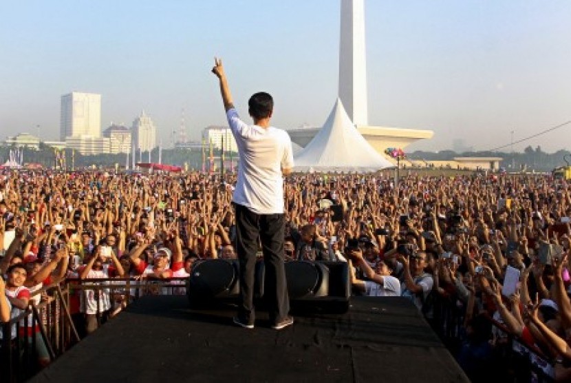 Joko Widodo (Jokowi) saat melepas ribuan peserta acara Gerak Jalan Revolusi Mental di Kawasan Monas, Jakarta, Ahad (22/6).