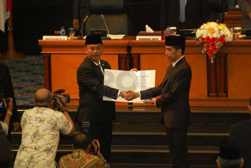 Joko Widodo (kanan) memberikan surat pengenduran diri kepada Ketua DPRD DKI, Prasetyo Edi Marsudi (kiri) di ruang sidang paripurna Gedung DPRD DKI, Jakarta Pusat, Kamis (2/10). (Republika/Raisan Al Farisi)