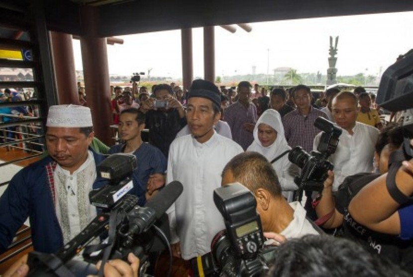 Joko Widodo (kedua kiri) dan istri Ny Iriana (kedua kanan) didampingi ketua rombongan Umrah Usamah Hisyam (kiri), berjalan menuju terminal keberangkatan saat akan menunaikan ibadah Umrah di terminal 2D Bandara Soekarno-Hatta, Tangerang, Banten, Ahad (6/7).