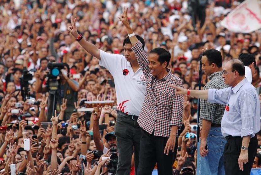 Joko Widodo (ketiga kanan) didampingi Tim pemenangan Capres Jokowi-JK Maruarar Sirait (keempat kanan), Anis Baswedan (kedua kanan) dan Tim pengarah Pemenangan Jokowi-JK Alwi Shihab (kanan) melambaikan dua jari kepada pendukungnya ketika Konser Salam dua Ja