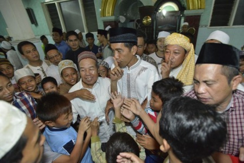 Joko Widodo (ketiga kanan) meminta anak-anak untuk tenang usai menunaikan ibadah shalat Taraweh pada malam pertama bulan Ramadan 1435 H di Masjid Ali Akbar, Sidosermo, Surabaya, Jawa Timur, Sabtu (28/6). 