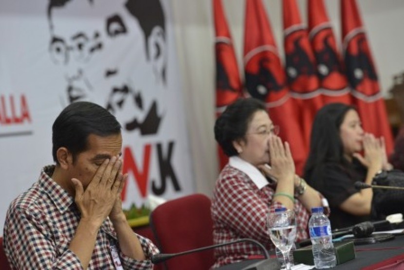 Joko Widodo (kiri) bersama Megawati Sukarnoputri (tengah) dan Puan Maharani (kanan) berdoa bersama sebelum acara rapat koordinasi kampanye Pilpres di Kantor DPP PDI Perjuangan, Lenteng Agung, Jakarta Selatan, Rabu (4/6). 