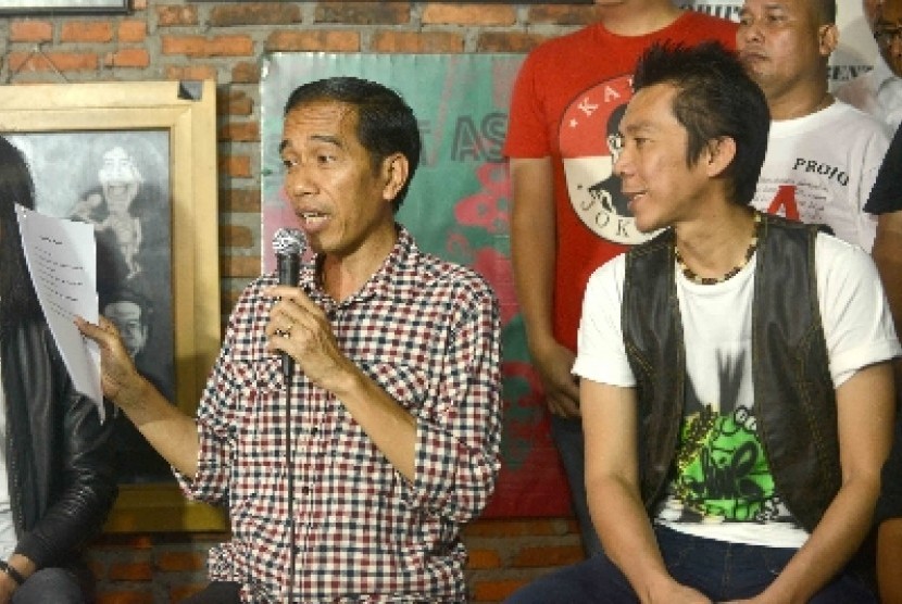 Joko Widodo (kiri) bersama personil Slank, Bimbim (kanan) memberi keterangan kepada wartawan usai melakukan pertemuan tertutup di markas Slank, Jl Potlot, Jakarta, Selasa (27/5). 