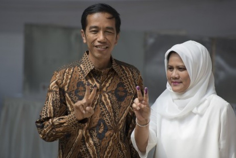 Joko Widodo (kiri) dan Isteri Ny Iriana (kanan) menunjukkan jari tangannya yang sudah tertoreh tinta pemilu usai mencoblos surat suara di TPS Nomor 18, Kelurahan Menteng, Jakarta Pusat, Rabu (9/7). 
