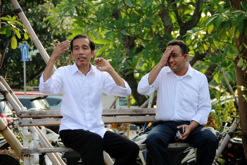 Joko Widodo (kiri) dan Juru Bicara Tim Pemenangan Pasangan Jokowi - JK, Anies Baswedan (kanan) duduk di bangku taman ketika berkunjung ke Taman Waduk Pluit di Jakarta Utara, Selasa (22/7). 