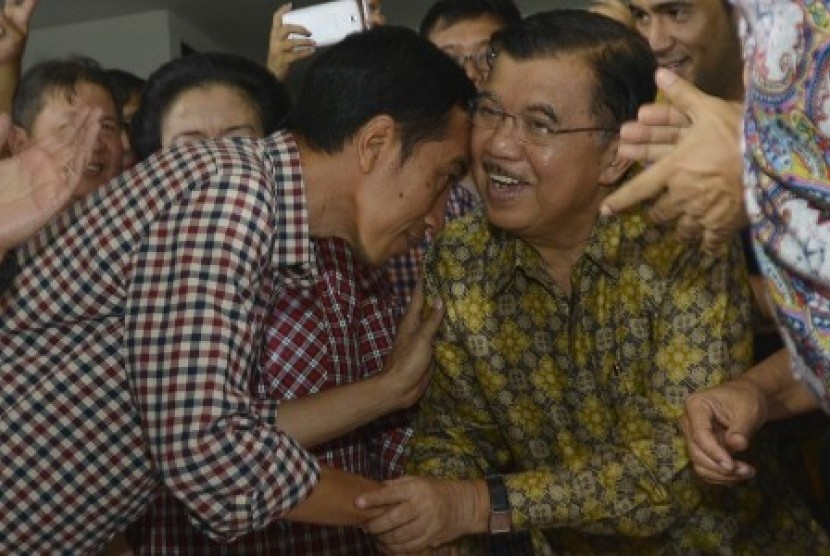 Joko Widodo (kiri) menyalami Jusuf Kalla (kanan)