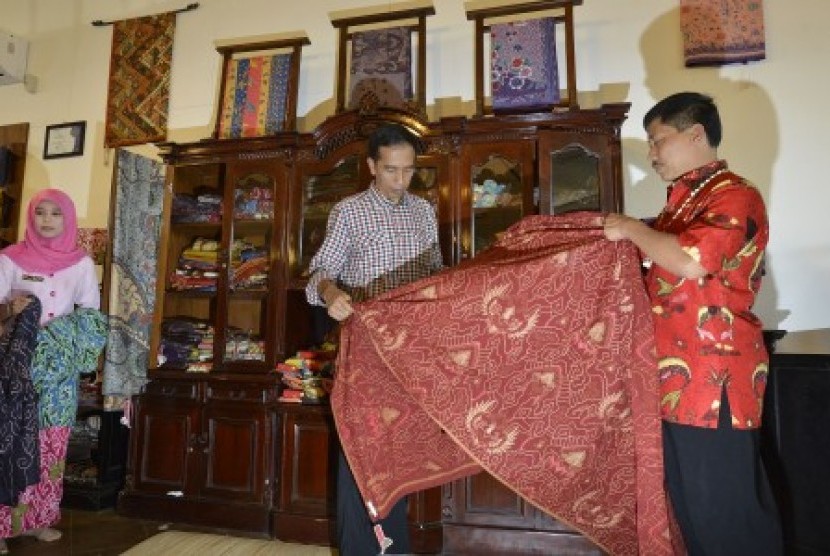  Joko Widodo (tengah) didampingi Bupati Cirebon Sunjaya Purwadi (kanan) melihat kain batik khas Cirebon di sela-sela kampanye di Pusat Batik Trusmi, Cirebon, Jawa Barat, Rabu (18/6). 