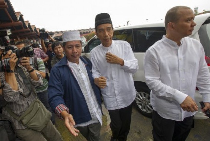 Joko Widodo (tengah) didampingi ketua rombongan Umrah Usamah Hisyam (kiri), berjalan menuju terminal keberangkatan saat akan menunaikan ibadah Umrah di terminal 2D Bandara Soekarno-Hatta, Tangerang, Banten, Ahad (6/7). 