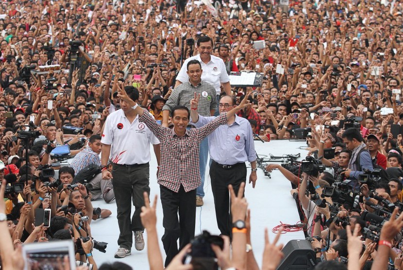 Joko Widodo (tengah) didampingi Tim pemenangan Capres Jokowi-JK Maruarar Sirait (kiri), Anis Baswedan (kedua belakang), Luhut Panjaitan (belakang) dan Tim pengarah Pemenangan Jokowi-JK Alwi Shihab (kanan) melambaikan dua jari kepada pendukungnya ketika Kon