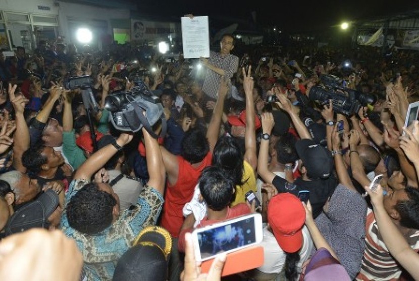 Joko Widodo (tengah) menyapa para pedagang pasar ketika berkunjung ke Pasar Induk Cibitung, Kabupaten Bekasi, Jawa Barat, Senin (16/6) malam. 