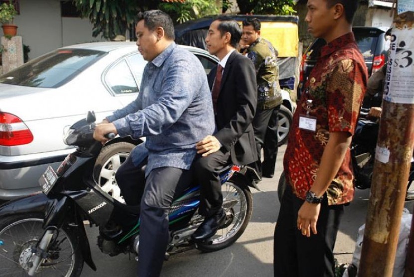 Jokowi dibonceng sepeda motor tidak menggunakan helm.