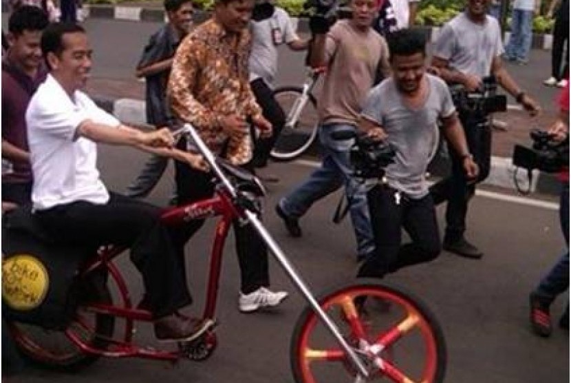 Jokowi mengendarai sepeda lowrider.