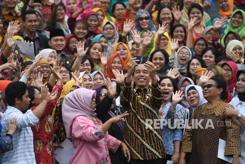 Jokowi Temui Komunitas Perempuan. Presiden Joko Widodo (tengah) berswafoto dengan komunitas perempuan akar rumput usai pertemuan di Istana Merdeka, Jakarta, Rabu (6/3/2019). 