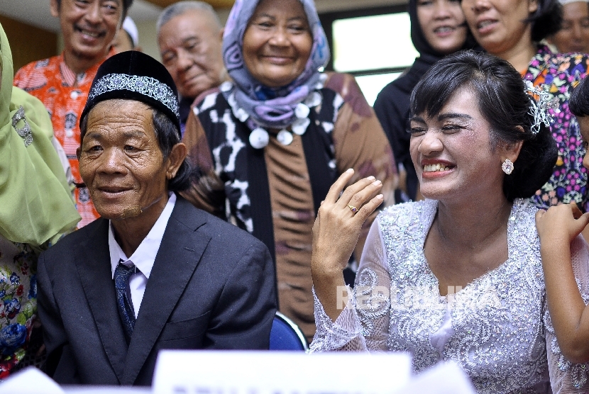   Joni (55) dan Isa (30) meperlihatkan cincin pernikahan seusai ijab kabul disaksikan Direktur Rehabilitas Sosial Anak Nahar (kiri) di Gedung Kelurahan Pekojan Tambora, Jakarta Barat, Jumat (7/7). 