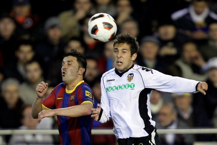 Jordi Alba (kanan) berduel dengan striker Barcelona David Villa